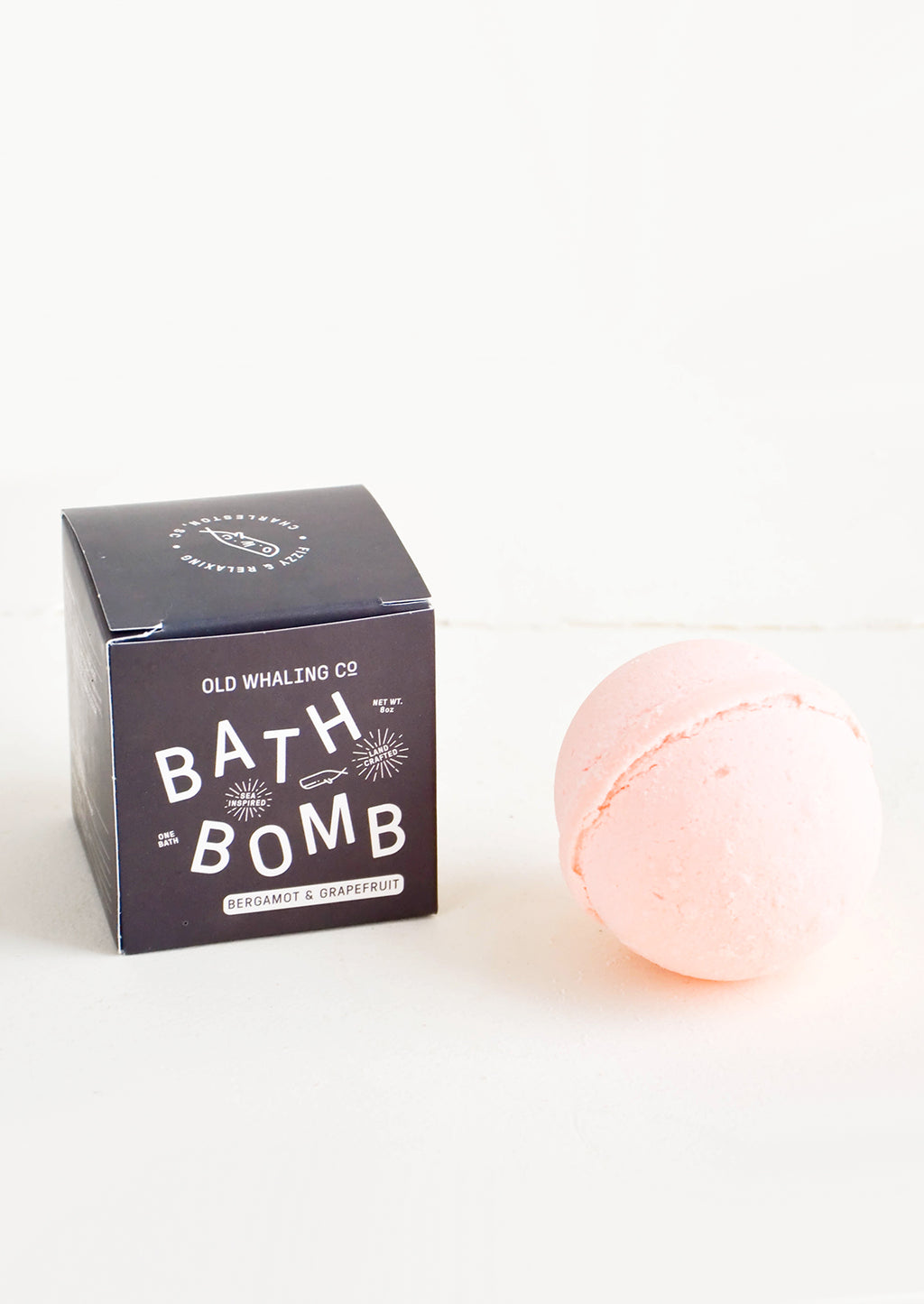 Bergamot & Grapefruit: Pink colored, round bath bomb with black box packaging