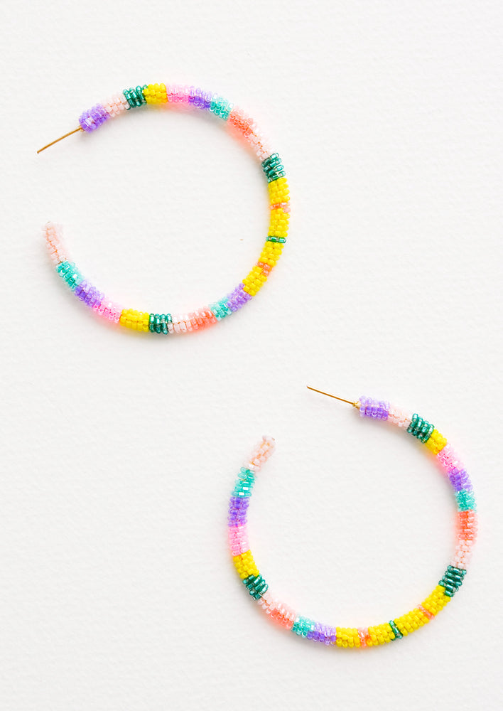 Hoop earrings with pink, yellow, aqua and purple glass beads arranged in a circle.