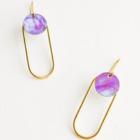 Galactic: Pair of earrings in the shape of a hollow brass oval with a painted purple dot at the top.