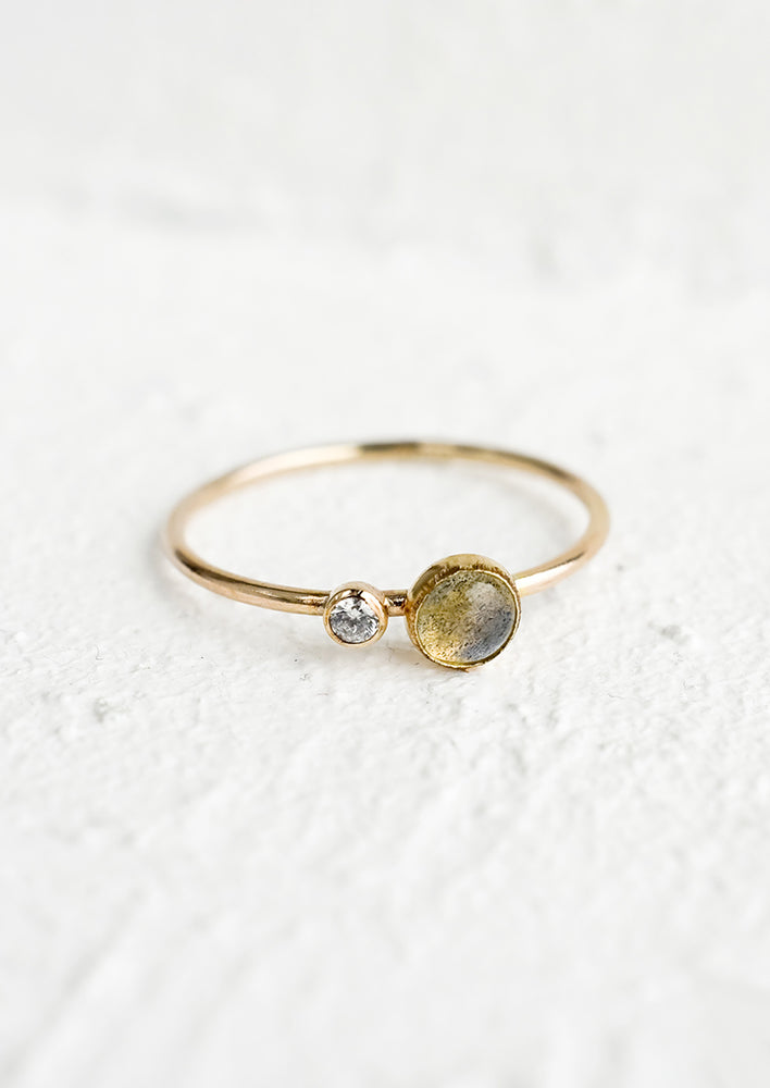 A gold ring with slim band and bezel set labradorite and clear CZ.