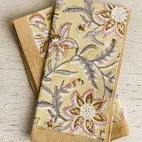 1: A pair of yellow floral paisley print napkins.