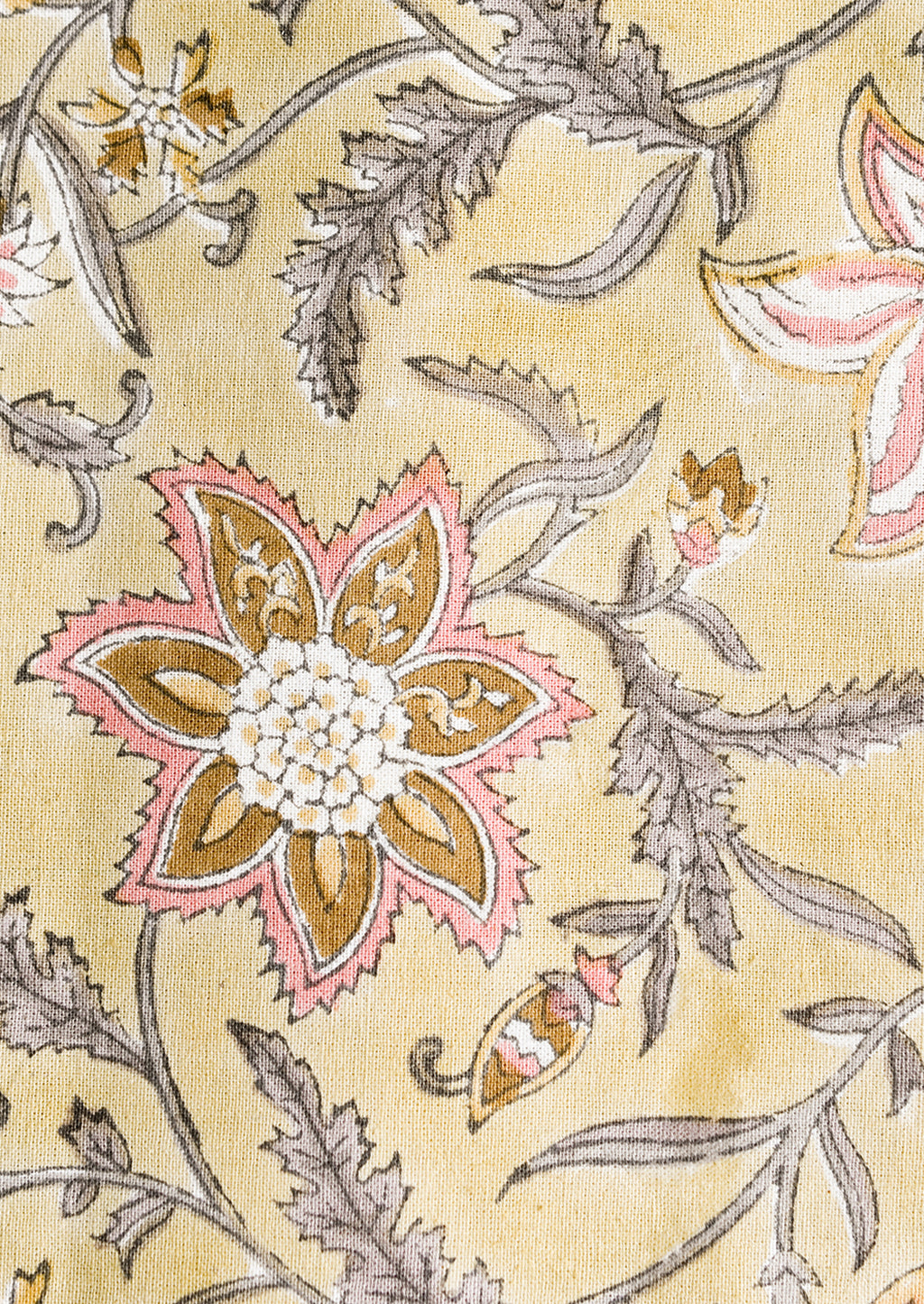 2: A pale yellow tablecloth with floral print in grey and pink.