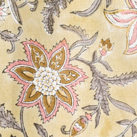 2: A pale yellow tablecloth with floral print in grey and pink.