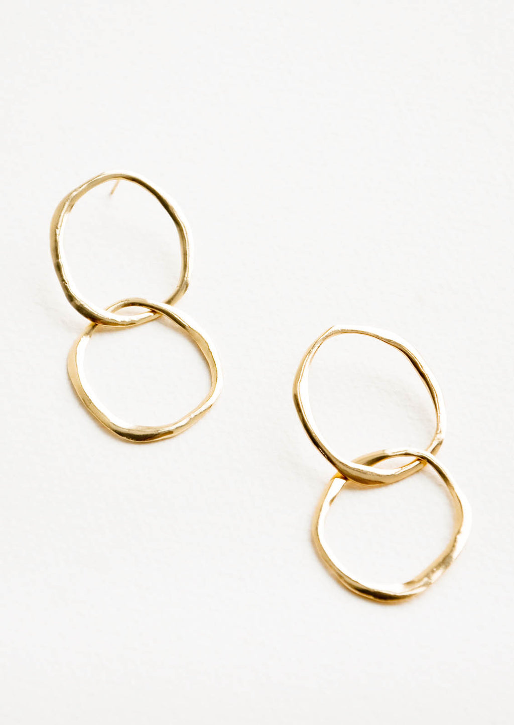 1: Gold drop earrings consisting of two interwoven hammered circles.
