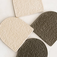 1: Textured, arch-shaped coasters in two colors.