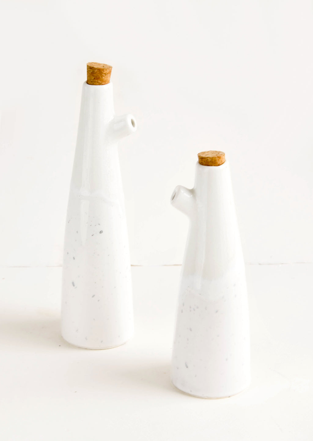 Small / White / Grey Splatter: Ceramic cruets for oil & vinegar, one taller than the other. Glossy white glaze, cork stopper as lid.