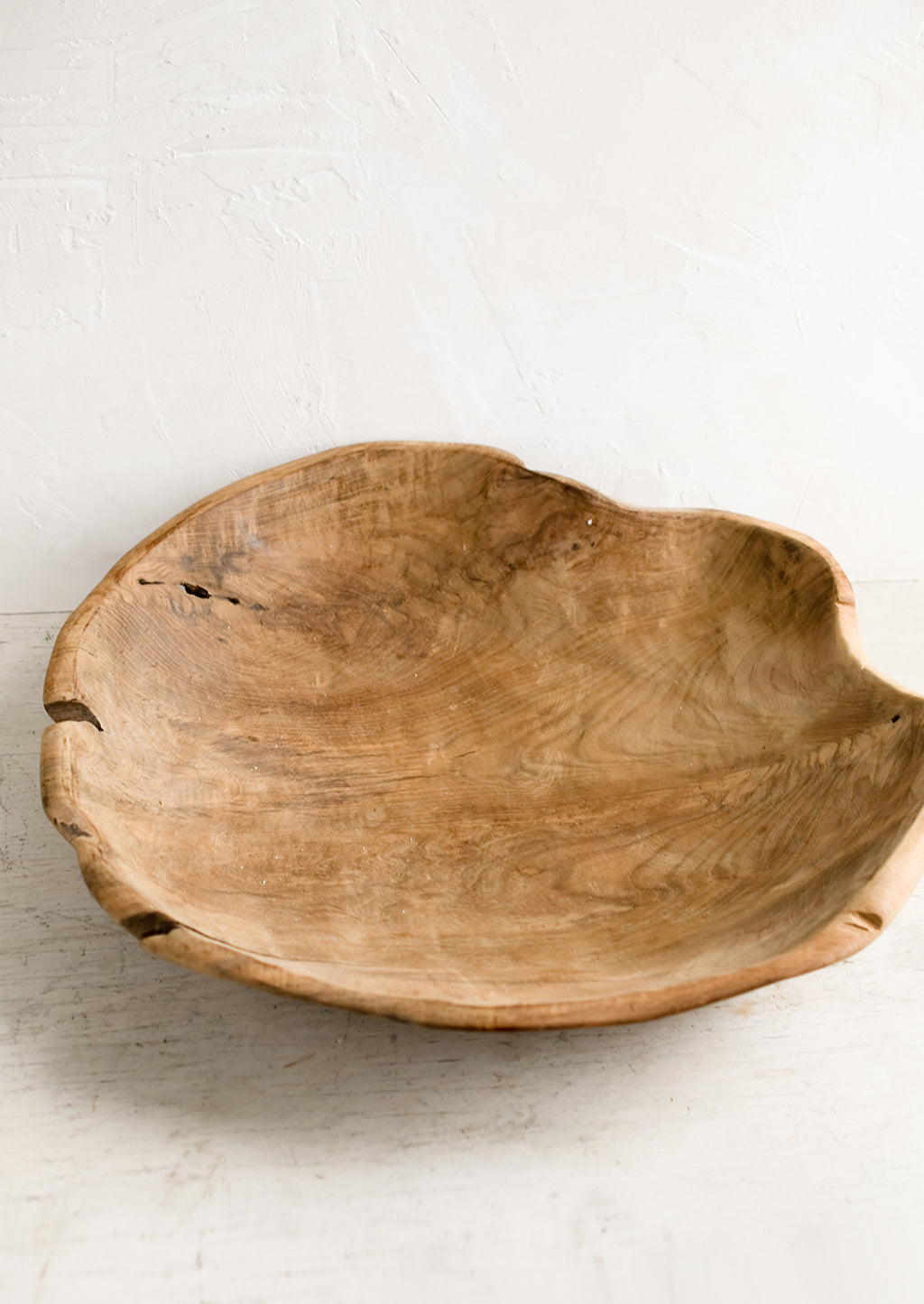 2: A large teak wood bowl with natural cracks and fissures.