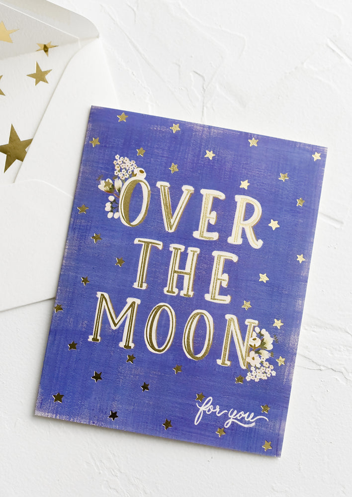 1: A greeting card with star print reading "Over the moon for you".