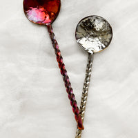 Twisted Handle: Oxidized metal spoons with twisted handles and oil slick finishes.