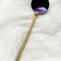 Two Tone: A metal spoon with brass handle and oil slick spoon.