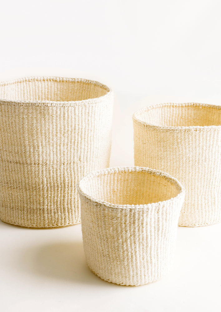2: Round storage baskets in three incremental sizes made from woven sisal fiber in natural bleached hue