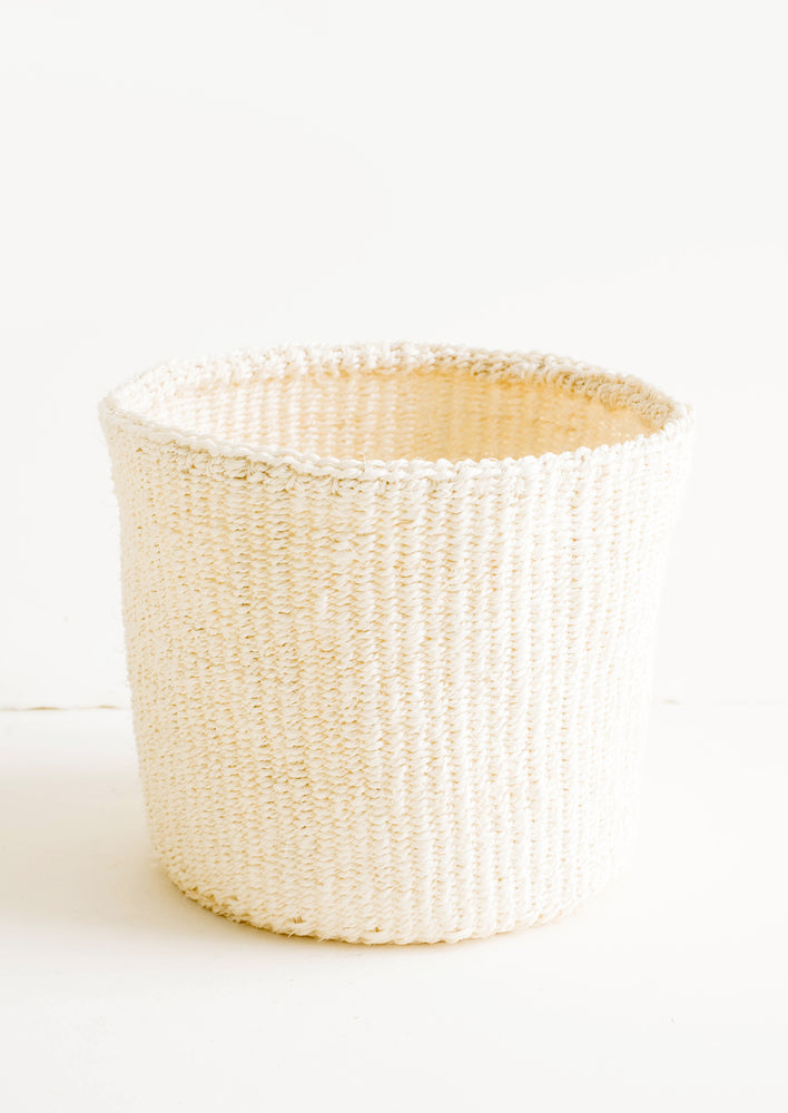 1: Round storage basket made from woven sisal fiber in natural bleached hue