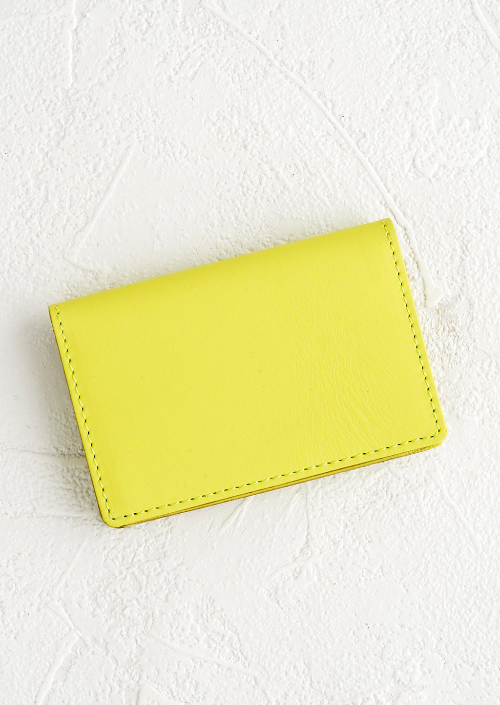 Neon Yellow: A small leather cardholder wallet in neon yellow.