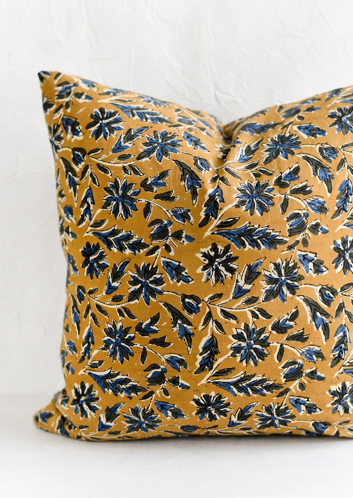 2: A block printed pillow with floral motif in blue and black on tan.