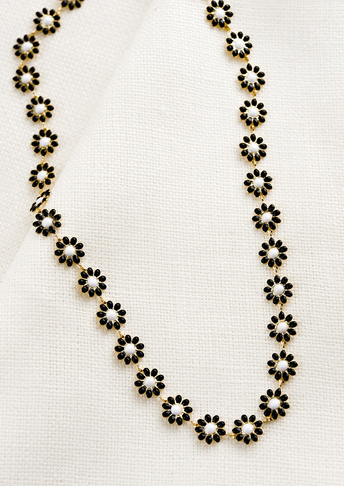 A necklace with allover black and white enamel flowers.