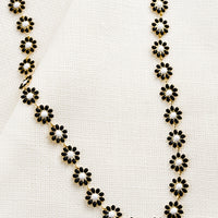 Black: A necklace with allover black and white enamel flowers.