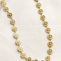White: A necklace with allover yellow and white enamel flowers.