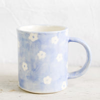 Periwinkle Daisy: A handmade ceramic mug with periwinkle background and hand-painted white flowers.