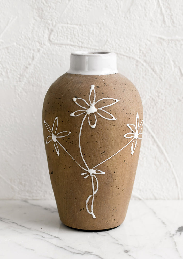 2: A brown clay vase with white floral sketch.