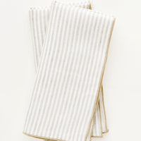 Flax Stripe: Pair of ivory folded Linen Napkins with light brown vertical stripe.
