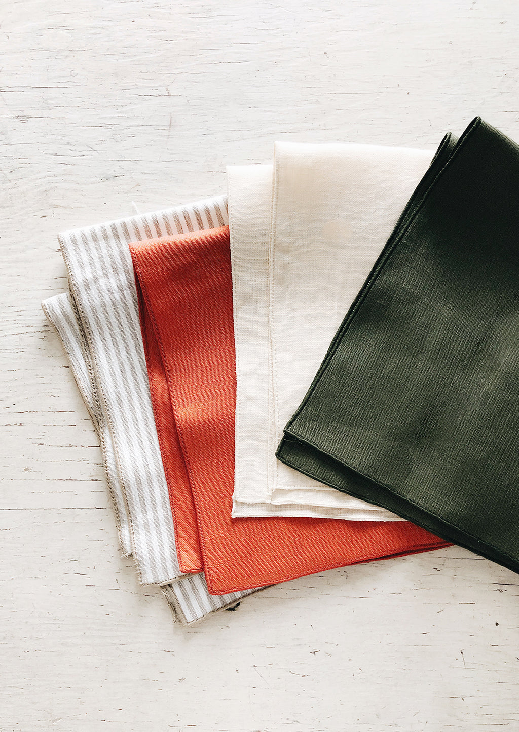 Tomato: Linen Napkins splayed out in an array of colors.