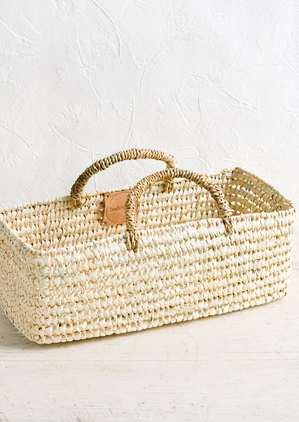 1: A skinny and narrow square storage basket with handles, made from natural dried palm.