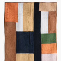 2: A paneled patchwork quilt in orange and brown tones.