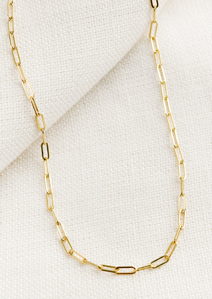 A gold necklace with paperclip chain links.