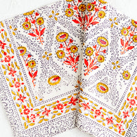 2: A block printed napkin in yellow, red, black and white floral pattern.