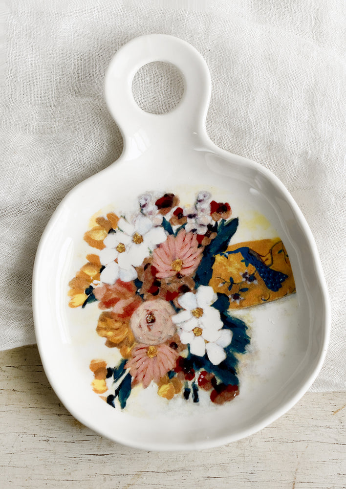 1: A white ceramic spoon rest with painterly floral design.