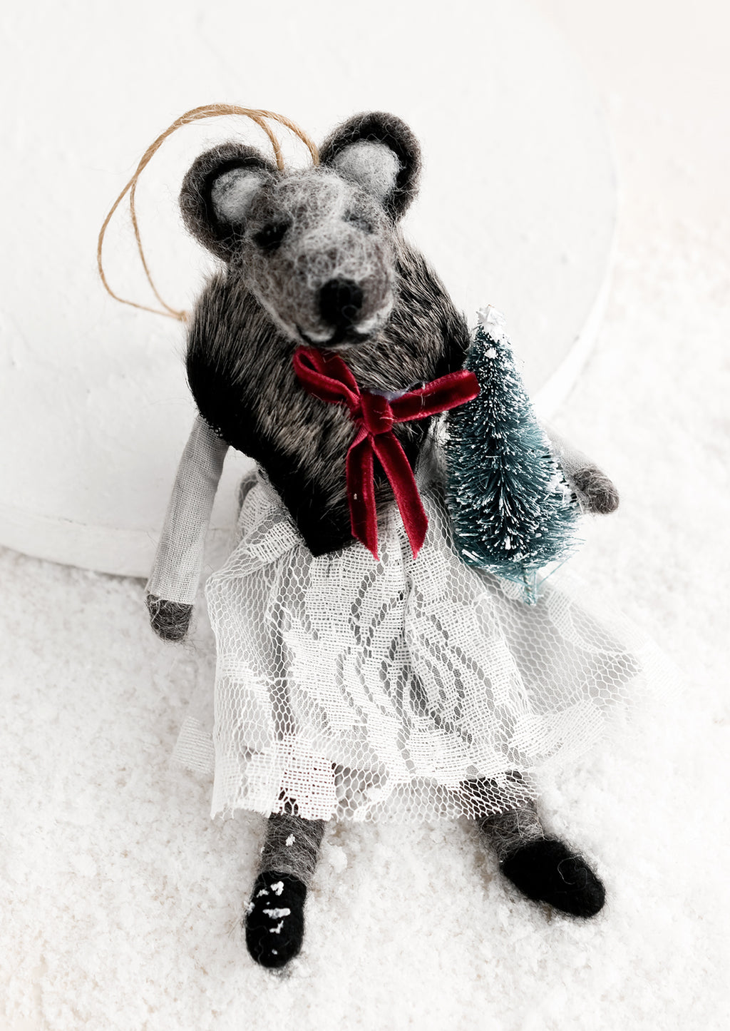 Tree: A felted holiday ornament of a badger wearing a dress, holding a tiny christmas tree.