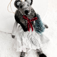 Tree: A felted holiday ornament of a badger wearing a dress, holding a tiny christmas tree.