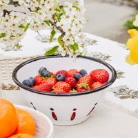 2: An enamel berry bowl on a table with berries.