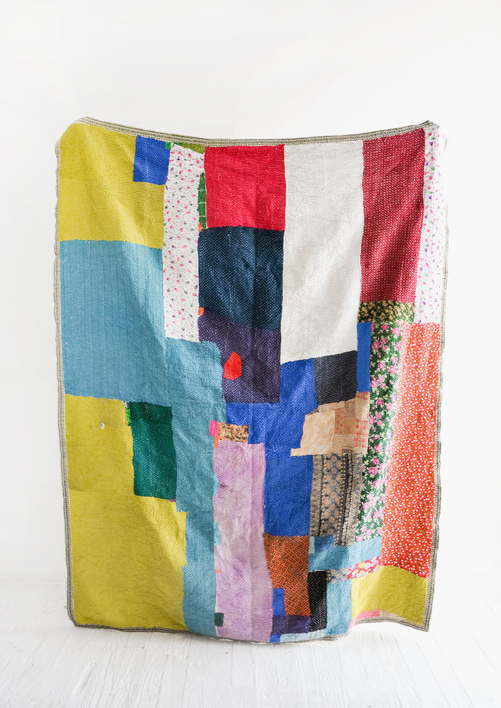Vintage patchwork quilt in a colorful mix of fabrics. All different shades of green, blue, red & more.
