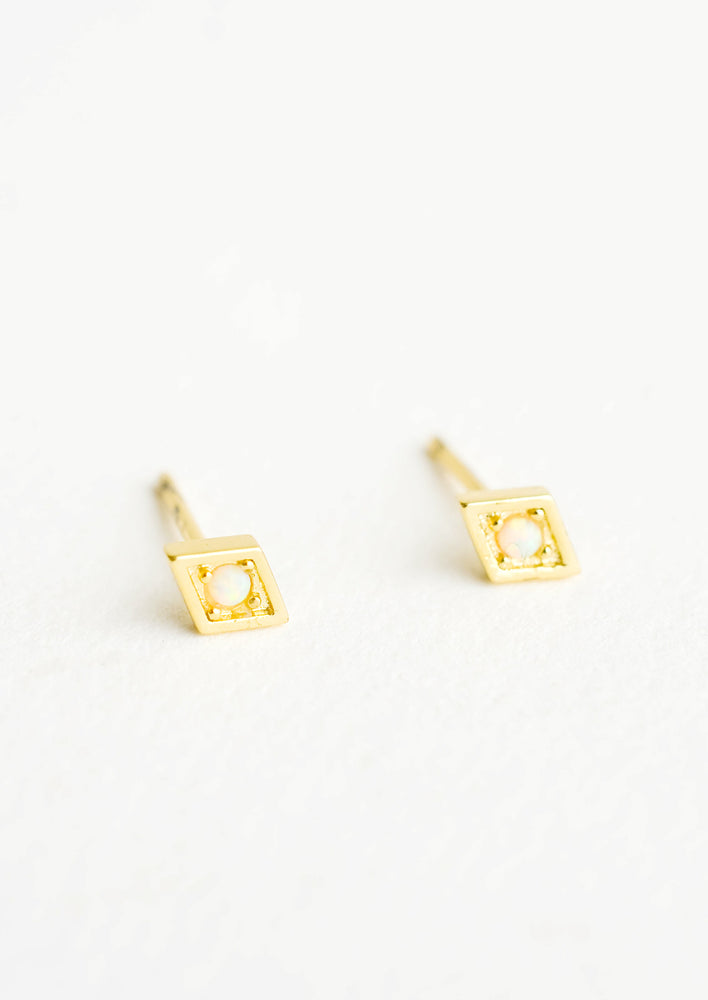 Diamond shaped stud earrings in gold finish, with small round opal stone inset.