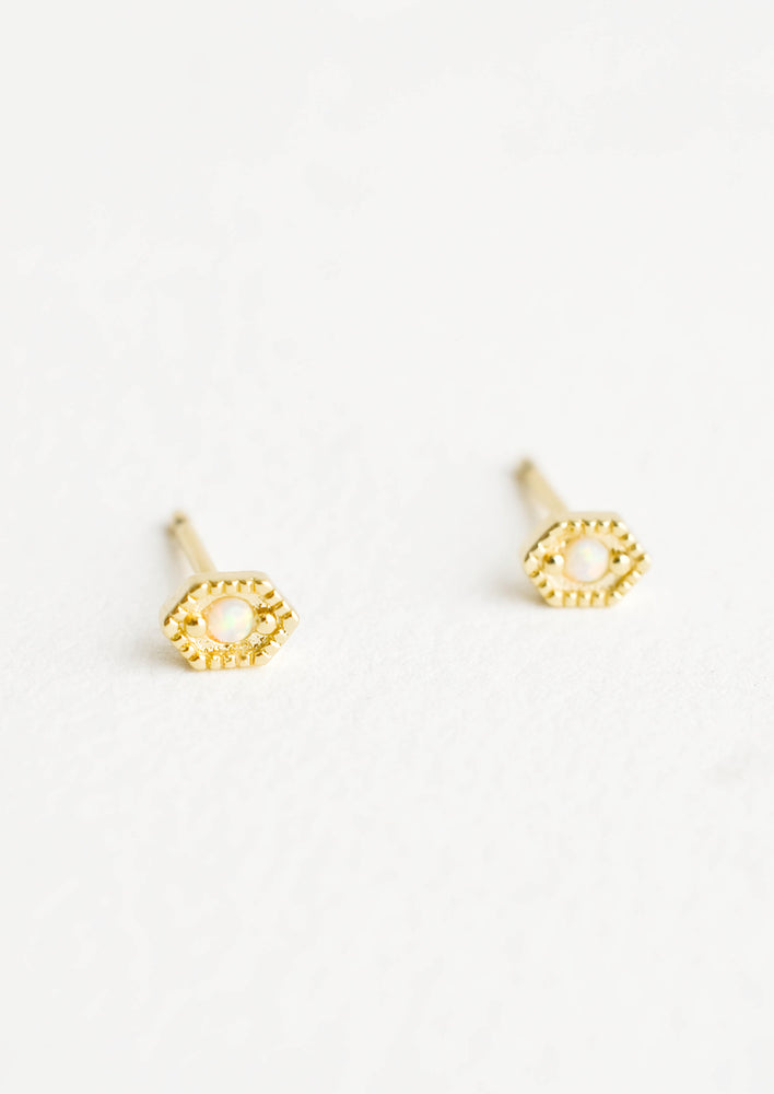 Hexagon shaped stud earrings in gold finish, with small round opal stone inset.
