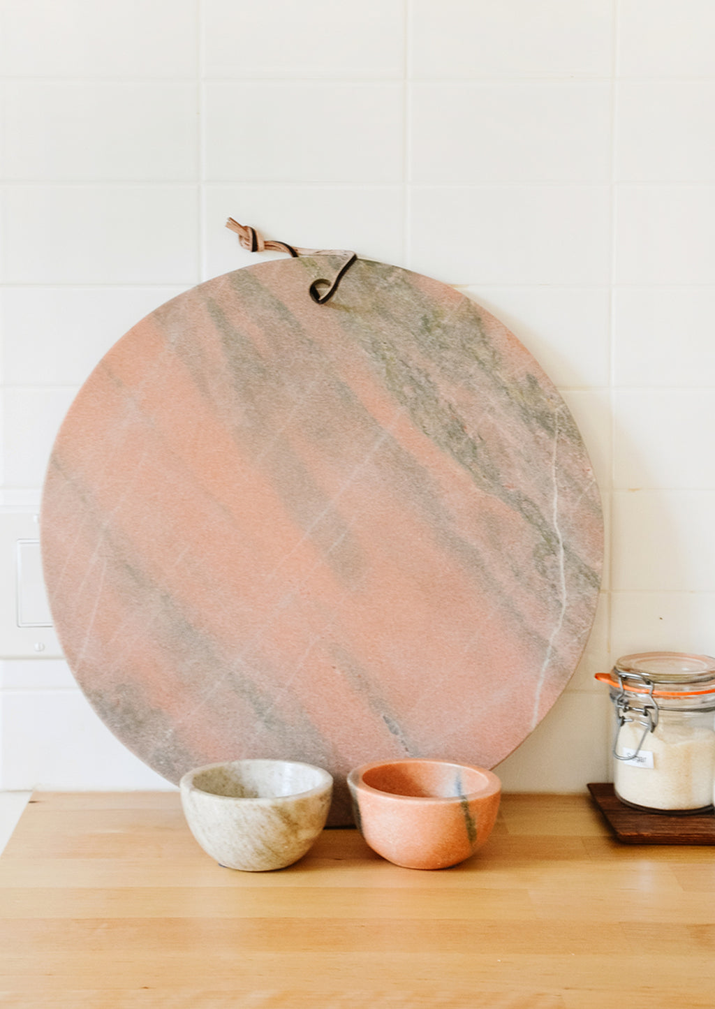 4: Pink and tan marble serving platter and prep bowls on a kitchen counter
