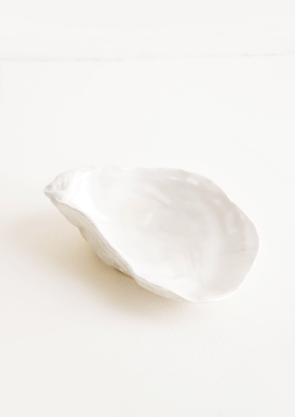 1: A small ceramic dish molded in the shape of an oyster half shell