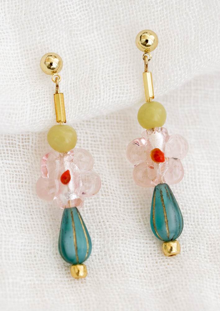A pair of multi beaded drop earrings with pink glass flower bead at center.