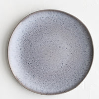 1: A round ceramic dinner plate in speckled periwinkle glaze.