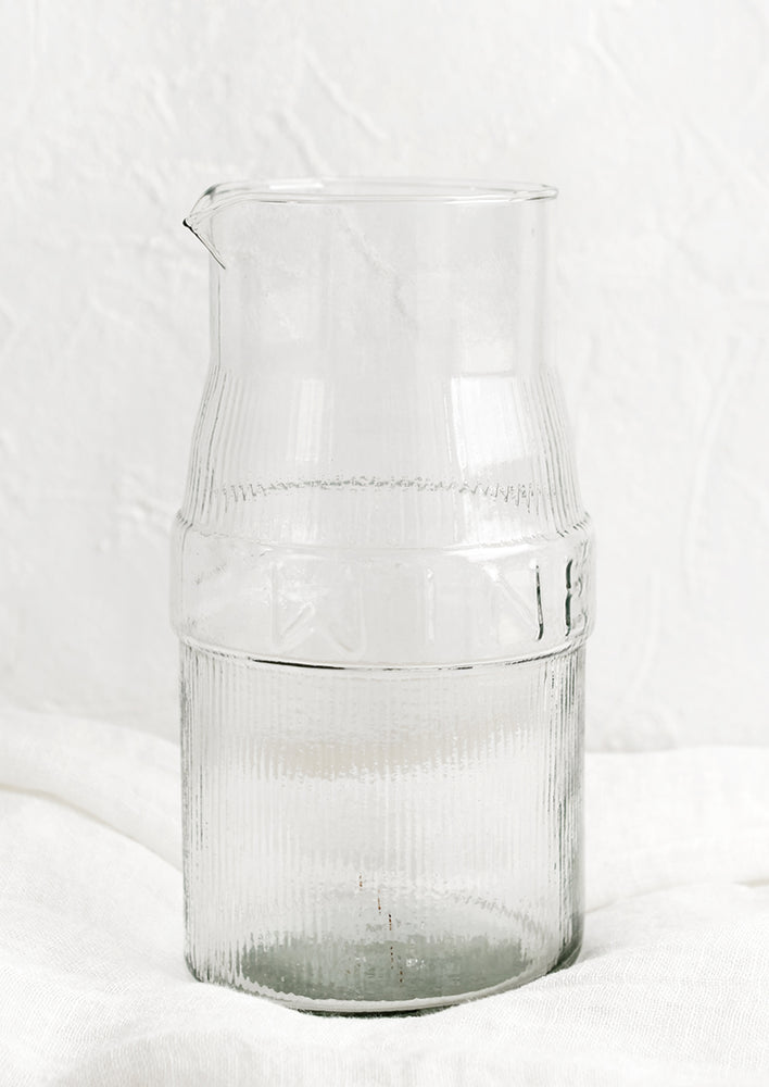 A glass decanter with ribbed texture and text reading "WINE".