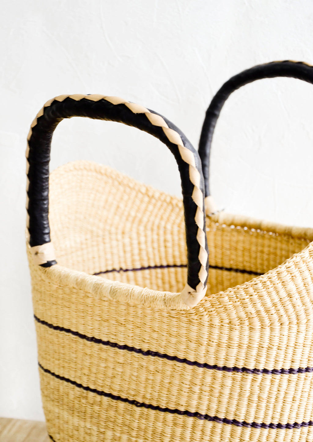 2: Leather handles on a woven totebag, woven in natural and black leather.