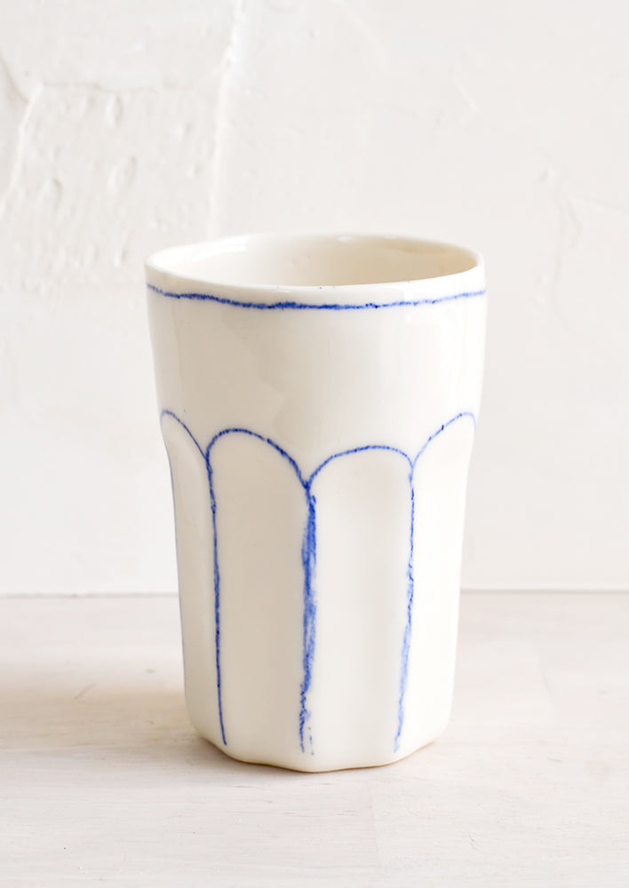 1: A ceramic tumbler with blue lines.