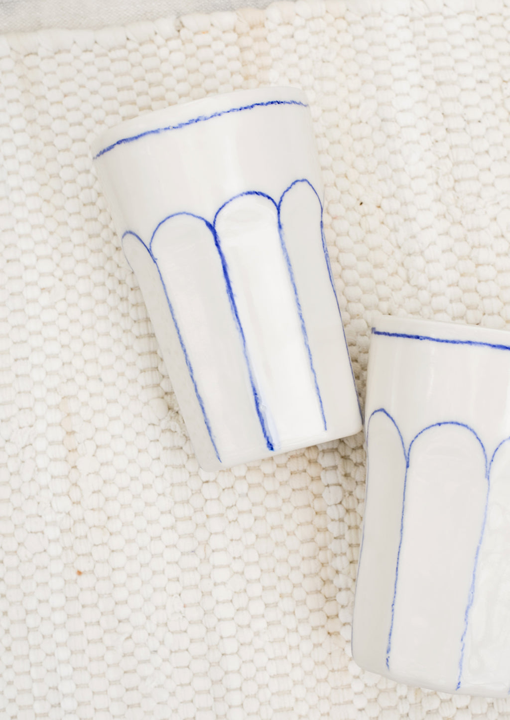 2: Two ivory ceramic tumblers.