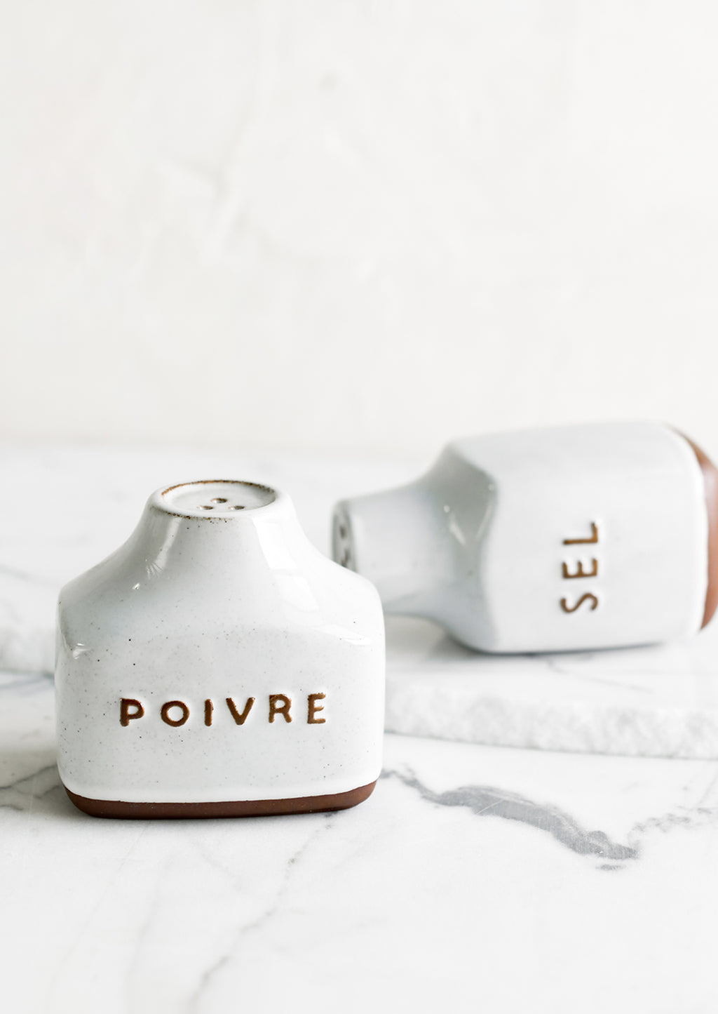 2: Ceramic salt and pepper shakers with text detail in French.