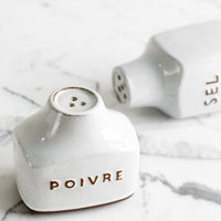 1: Ceramic salt and pepper shakers with text detail in French.