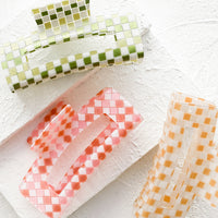 1: Three square hair claws in checkered print and assorted hues.