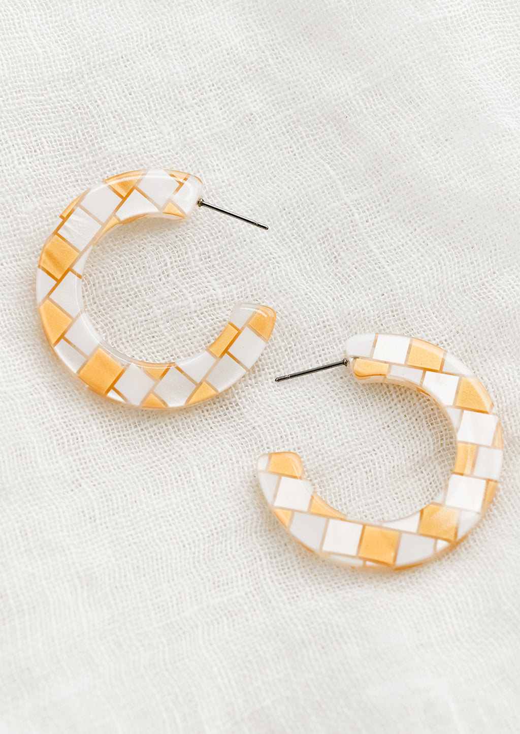 Gold: A pair of checkered earrings in gold.