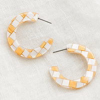 Gold: A pair of checkered earrings in gold.