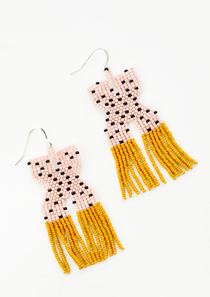 1: Pink x-shaped beaded earrings with black polka dots and mustard yellow fringe.
